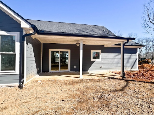 back of house with roof with shingles, a patio area, and a ceiling fan