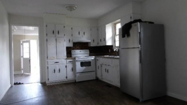 146 Garden Dr, Lafayette, TN 37083 - kitchen with freestanding refrigerator, white electric range, under cabinet range hood, white cabinets, and dark countertops