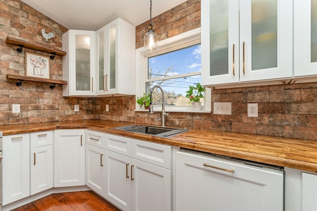 kitchen with butcher block countertops, decorative light fixtures, and white cabinetry