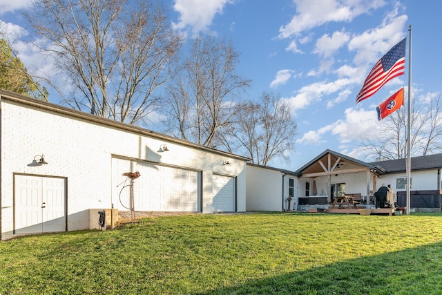 exterior space featuring a garage, a yard, and a wooden deck