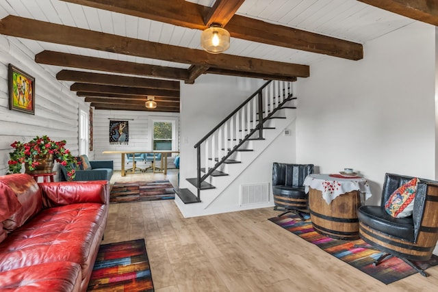 living room featuring beam ceiling, wooden walls, hardwood / wood-style floors, and wooden ceiling