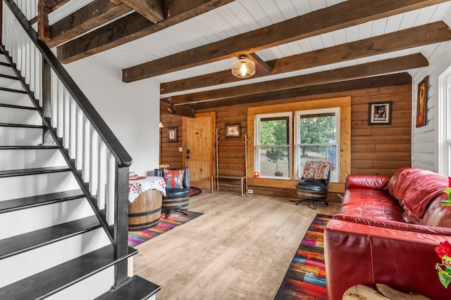 living room featuring beam ceiling, hardwood / wood-style flooring, wood ceiling, and wood walls