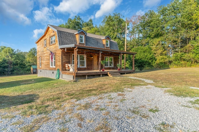 cabin with covered porch and a front yard