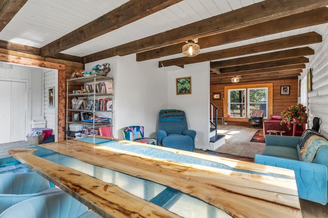 living room featuring beamed ceiling, hardwood / wood-style floors, and wood walls