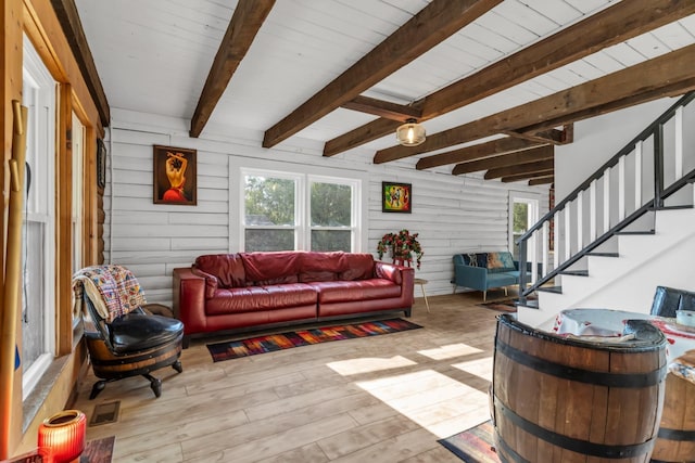 living room with beamed ceiling, wood walls, light wood-type flooring, and wooden ceiling