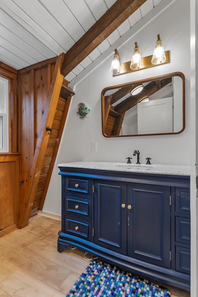 bathroom featuring vanity, hardwood / wood-style floors, beamed ceiling, and wooden ceiling