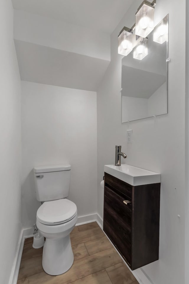 bathroom with wood-type flooring, vanity, and toilet