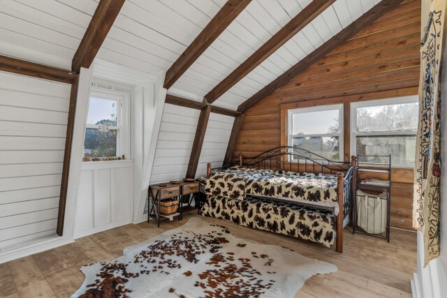 bedroom featuring vaulted ceiling with beams, wood walls, wood ceiling, and light wood-type flooring