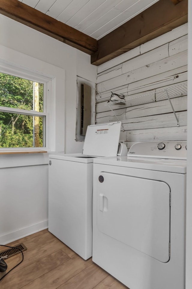 laundry room featuring washer and dryer, light wood-type flooring, electric panel, and wood ceiling