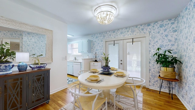 dining room featuring light wood-type flooring, sink, and french doors