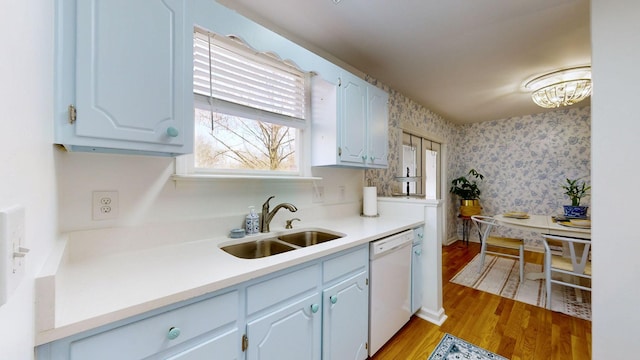 kitchen featuring dishwasher, light wood-type flooring, white cabinets, and sink