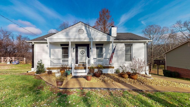 bungalow with covered porch and a front lawn