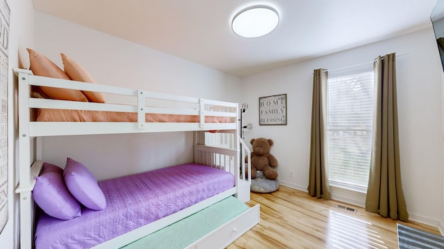 bedroom featuring multiple windows and light hardwood / wood-style flooring