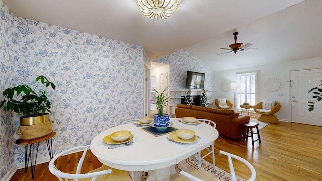 dining area featuring ceiling fan, wood-type flooring, and vaulted ceiling