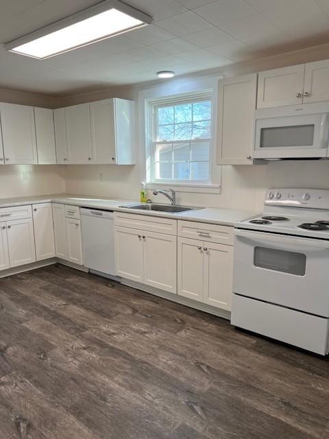 kitchen with white cabinets, dark hardwood / wood-style floors, white appliances, and sink