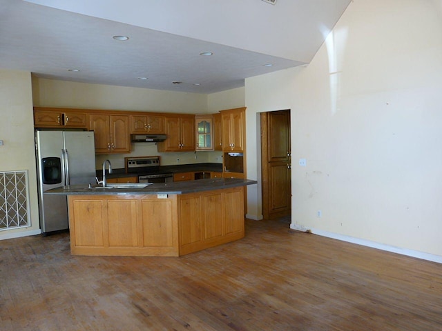 kitchen with stainless steel refrigerator with ice dispenser, a center island with sink, range with electric stovetop, and hardwood / wood-style floors