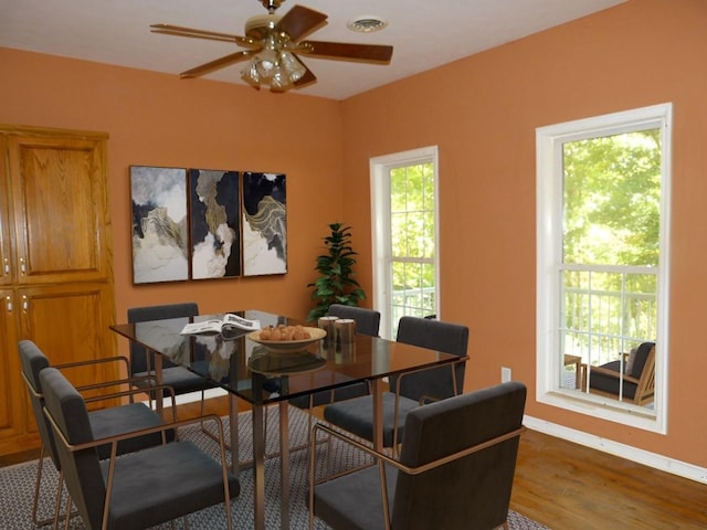 dining space with dark hardwood / wood-style flooring and ceiling fan