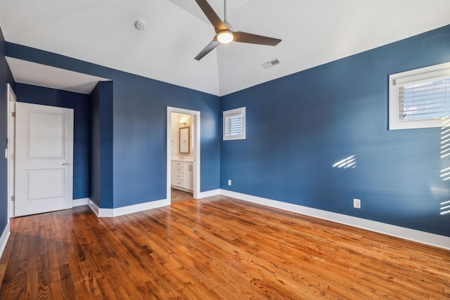 unfurnished bedroom featuring wood-type flooring, ensuite bathroom, and ceiling fan