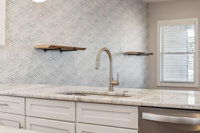 details featuring open shelves, stainless steel dishwasher, white cabinets, and light stone countertops