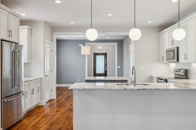 kitchen featuring stainless steel appliances, white cabinets, and hanging light fixtures