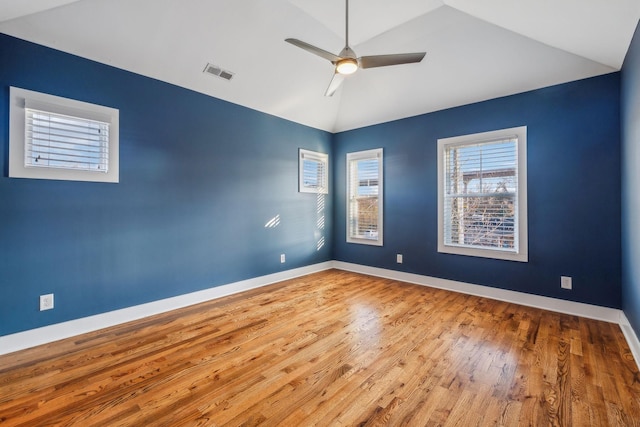 unfurnished room featuring visible vents, baseboards, ceiling fan, wood finished floors, and high vaulted ceiling