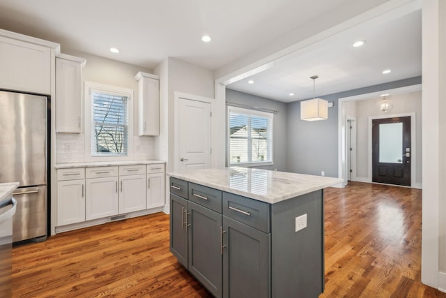 kitchen featuring stainless steel fridge, gray cabinets, white cabinetry, and dark wood-type flooring