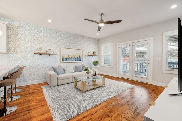 living area featuring baseboards and wallpapered walls