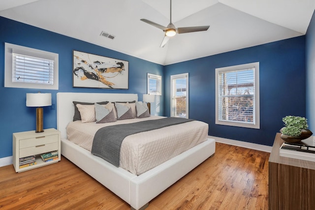 bedroom featuring lofted ceiling, wood finished floors, a ceiling fan, visible vents, and baseboards