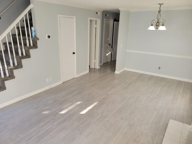 interior space with light hardwood / wood-style flooring, a notable chandelier, and crown molding