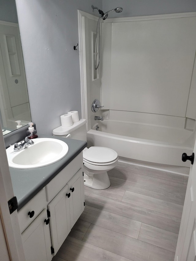 full bathroom with hardwood / wood-style floors, vanity, shower / bathtub combination, and toilet