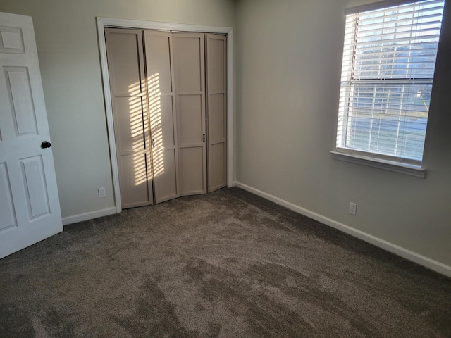 unfurnished bedroom with dark colored carpet