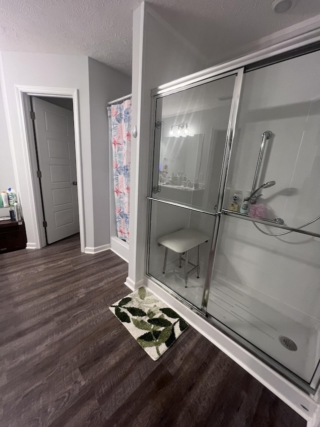 bathroom featuring hardwood / wood-style flooring, a textured ceiling, and walk in shower