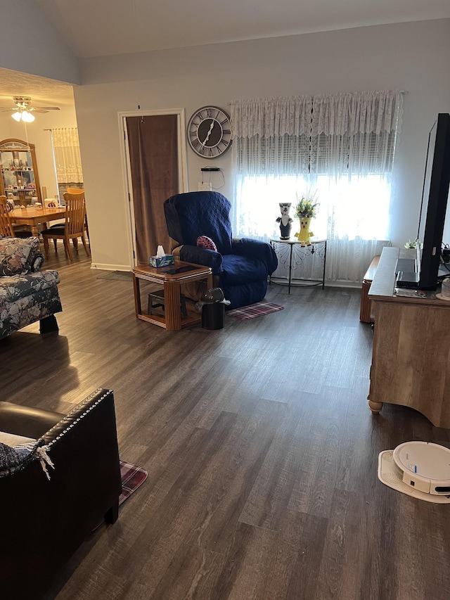 living room featuring plenty of natural light, ceiling fan, dark hardwood / wood-style flooring, and vaulted ceiling