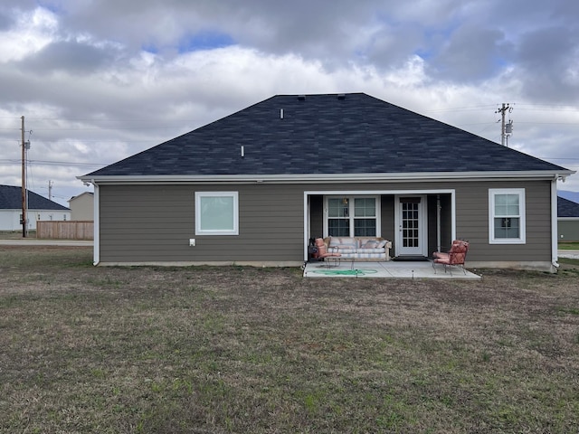 rear view of property featuring a lawn and a patio area