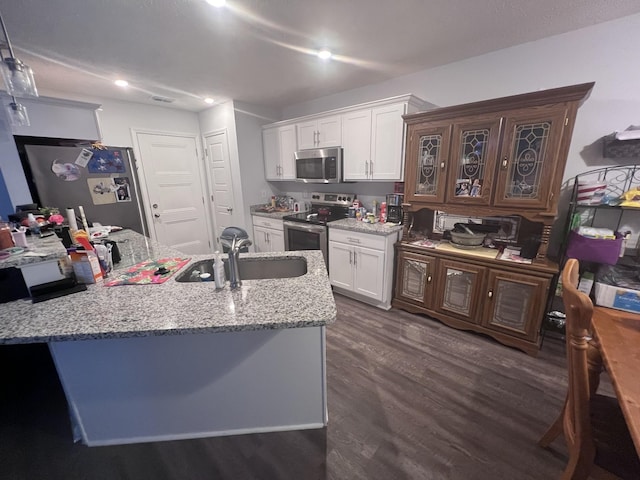 kitchen with light stone countertops, sink, stainless steel appliances, dark hardwood / wood-style flooring, and white cabinets