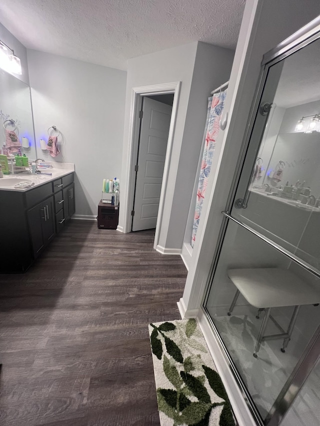 bathroom with hardwood / wood-style flooring, vanity, a shower with curtain, and a textured ceiling