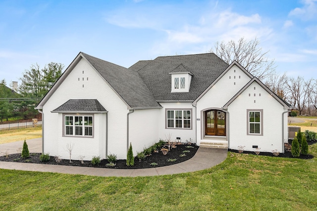 french provincial home with a front yard and french doors