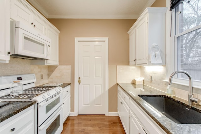 kitchen with white cabinetry, sink, ornamental molding, white appliances, and light wood-type flooring