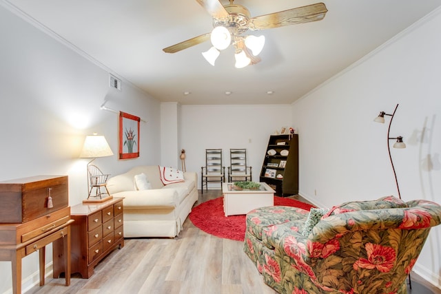 living room featuring light wood-type flooring, ceiling fan, and crown molding