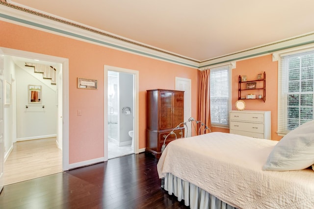 bedroom with connected bathroom, crown molding, and dark hardwood / wood-style flooring