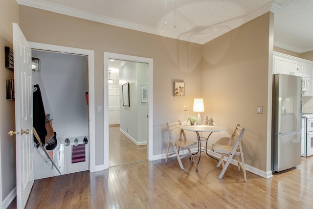 dining space with light wood-type flooring and crown molding