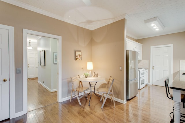 dining space featuring a textured ceiling, light hardwood / wood-style floors, and crown molding