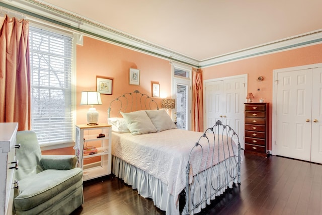 bedroom with ornamental molding and dark wood-type flooring