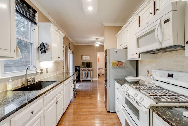 kitchen with sink, light hardwood / wood-style flooring, crown molding, white appliances, and white cabinets