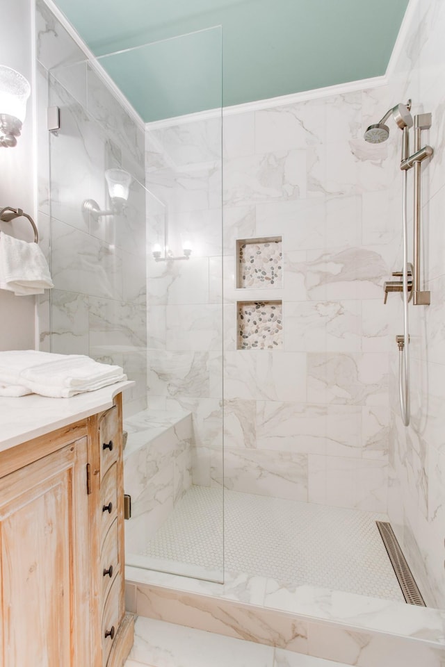 bathroom with a tile shower and vanity