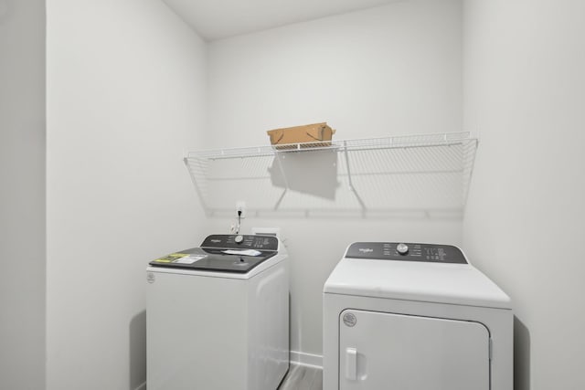 washroom featuring laundry area, independent washer and dryer, and wood finished floors