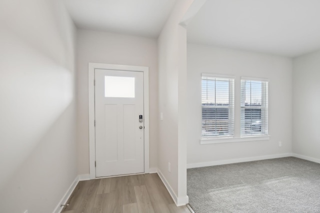 foyer entrance featuring light wood-style flooring and baseboards