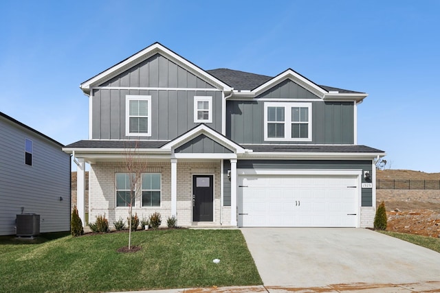 craftsman-style house featuring board and batten siding, a front yard, central AC, and brick siding