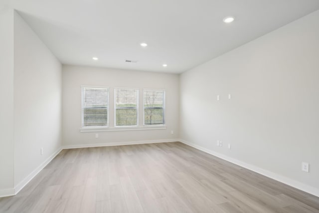 unfurnished room featuring baseboards, light wood-type flooring, visible vents, and recessed lighting