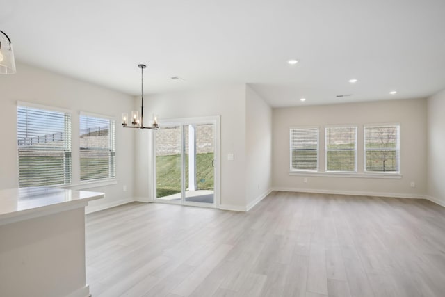 unfurnished dining area featuring light wood-type flooring, plenty of natural light, baseboards, and recessed lighting